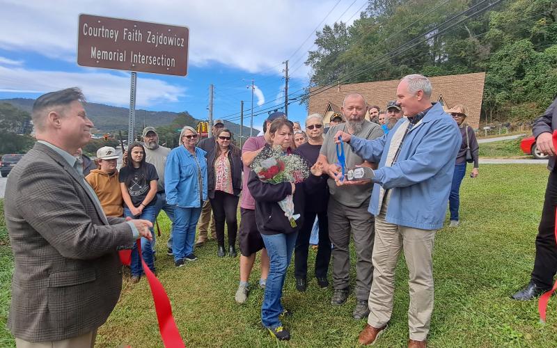Megan Horn/The Clayton Tribune. Forward Rabun/Rabun County Chamber of Commerce members, family and friends, as well as local officials and community members cut the ribbon on the Highway 76 and Highway 441 “Courtney Faith Zajdowicz Memorial Intersection.” Zajdowicz passed away on Sept. 1, 2021.