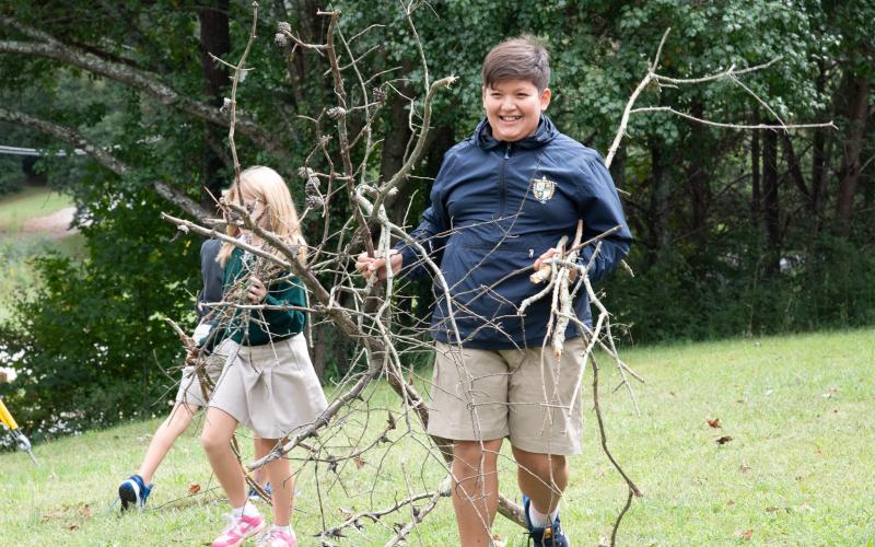 Submitted photo. TFS fifth grader Riley McCracken cleans up debris on the Get Real Ministries property during the Be The Light service project.