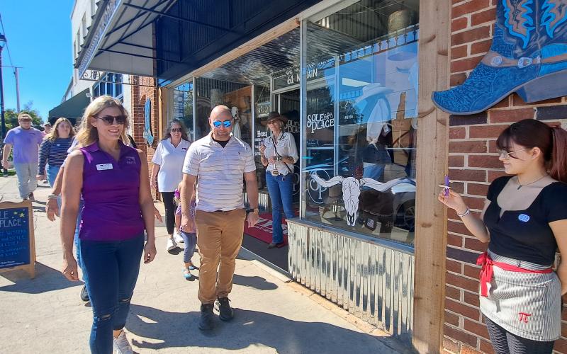 Megan Horn/The Clayton Tribune. Community members and domestic violence survivors walk in solidarity around Main Street during the third annual Hope Walk on Wednesday, Oct. 2, to bring awareness to Domestic Violence Awareness Month. During the walk, business owners and employees stood outside their storefronts with candles as a message of solidarity uniting with victims and other community members.