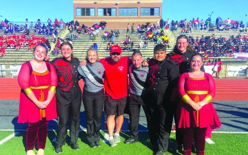 Following the Jaguar Classic, Lillian Seabolt, color guard captain; Lilly Padgett, drumline captain; Ashleigh Lewis, head drum major; Matthew Leff, RCHS director of bands; Jaden Horner, assistant drum major; Maxi Barrientos, band captain; Brady Mazarky, drumline captain; and Abby Streetman, color guard captain pose for a group photo.