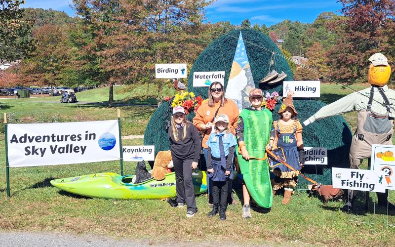 Megan Horn/The Clayton Tribune.  Pictured in front of the Second Place winner of the Sky Valley Hay Bale Trail contest titled “Adventures in Sky Valley” are Ella Owens, Ashley Whitmire, Ruby Whitmire, Amos Whitmire and Zailynn Whitmire. Dog “Doc” took home Most Unique Small Dog Costume in the dog costume parade dressed as a Sheriff. Below: Veterans of Foreign Wars (VFW) Post 4570 cooked hotdogs for the community at the Sky Valley Fall Fest.