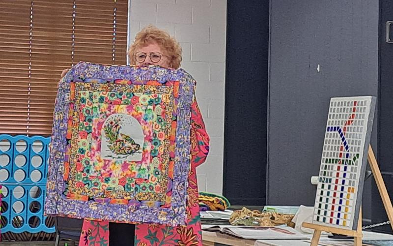 Megan Horn/The Clayton Tribune.  North Georgia Arts Guild member Silke Cliatt showcases this beautifully colored and embroidered quilt at the members’ Show and Tell. Below:  Joey Aldrich-Burel presents her painting in pastels that was inspired by Vincent Van Gogh.