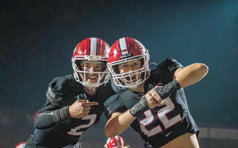 Wade Cheek/The Clayton Tribune. Rabun County quarterback Ty Truelove points out a message on teammate Carver Jarrard’s wrists of “Get Some” during the Wildcats’ regular-season game against Elbert County. RCHS plays Fitzgerald Friday.