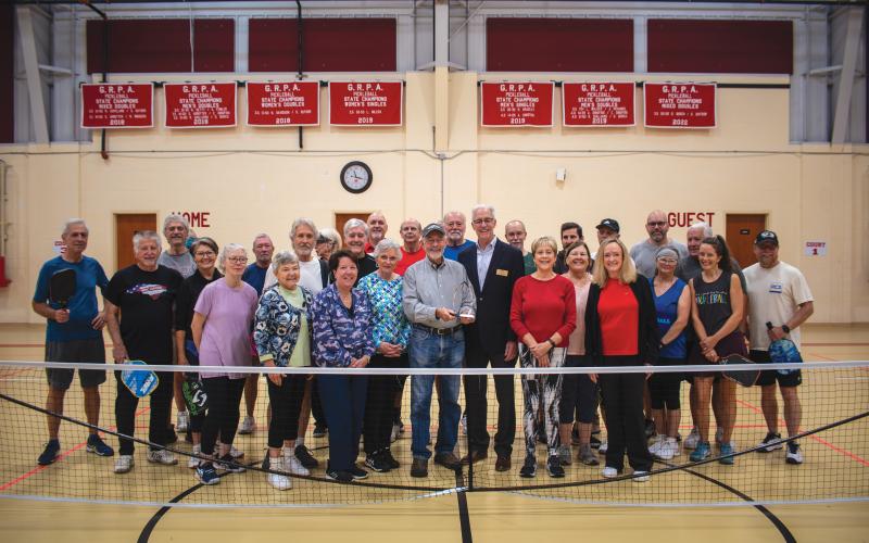 Wade Cheek/The Clayton Tribune. With Larry Walker holding the award, Rabun Pickleball Club members celebrate being named the GRPA’s statewide “Volunteer of the Year.”