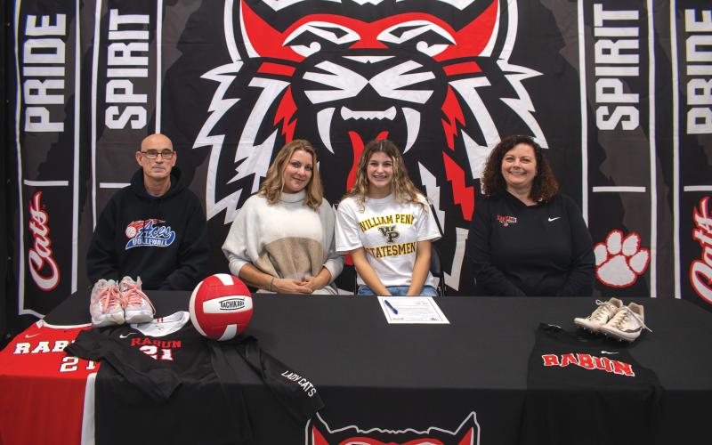 Wade Cheek/The Clayton Tribune. RCHS senior and three-sport athlete Arabella Kitchens signs her national letter of intent to compete in volleyball and track and field at William Penn University on Nov. 15. Kitchens (third from left) is joined by (from left) club volleyball coach David Provine, mother Tambrie Kitchens, and head varsity coach April Jones.