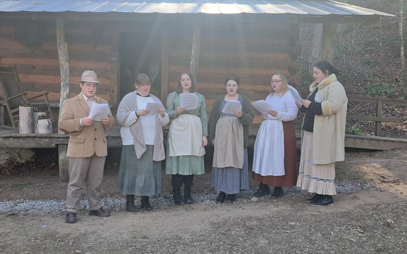 Megan Horn/The Clayton Tribune. Visitors to The Foxfire Museum during “A Foxfire Christmas” enjoyed hearing caroling at the Warwoman Cabin on Dec. 7. Inside, visitors enjoyed cookies and biscuits. Carolers pictured are Andrew Leff (left), Sarabeth Speed, Gracie Queen, Marley Turpin, Caramie Mills and Lilly Seabolt.