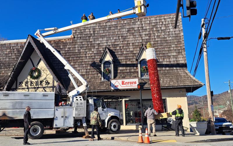 Megan Horn/The Clayton Tribune. City of Clayton workers spend hours on Monday installing the iconic candle atop Reeves at the intersection of Main Street and East Savannah Street. Santa Claus will light the candle on Saturday, Dec. 7, at the end of the parade.