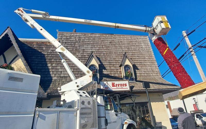Megan Horn/The Clayton Tribune. City of Clayton workers spend hours on Monday installing the iconic candle atop Reeves at the intersection of Main Street and East Savannah Street. Santa Claus will light the candle on Saturday, Dec. 7, at the end of the parade.