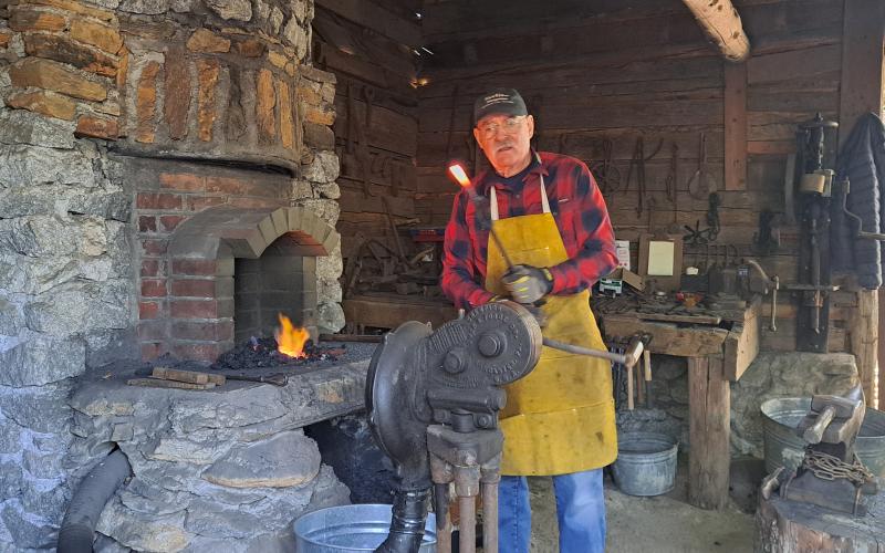 Megan Horn/The Clayton Tribune. Blacksmith Eric Towers demonstrates his trade to crowds of people at the Foxfire Village during “A Foxfire Christmas” Saturday, Dec. 7.