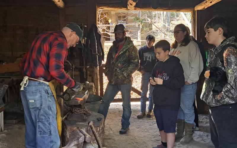 Megan Horn/The Clayton Tribune. Blacksmith Eric Towers demonstrates his trade to crowds of people at the Foxfire Village during “A Foxfire Christmas” Saturday, Dec. 7.