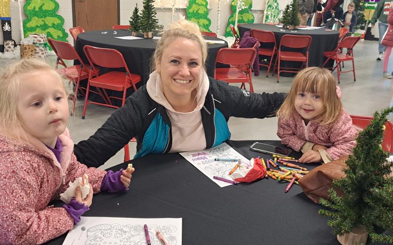 Megan Horn/The Clayton Tribune. The Dec. 5 “Santa on the Farm” event was full of family-friendly fun and activities. Savannah Saulsbury, 4, left; Alexis Saulsbury; and Sierra Saulsbury, 2, enjoy coloring a fun holiday picture.