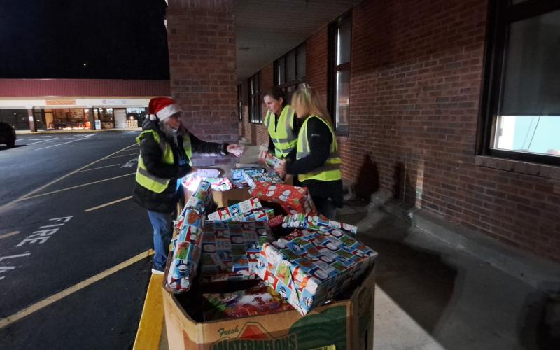 Megan Horn/The Clayton Tribune. Volunteers help distribute hundreds of gifts to children in the community during Monday’s Toy Drive at the Food Bank of Northeast Georgia.  Earlier in the day, the Teaching Kitchen had baked sugar cookies for children to decorate.