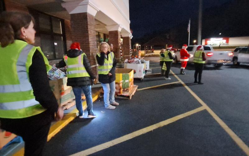 Megan Horn/The Clayton Tribune. Volunteers help distribute hundreds of gifts to children in the community during Monday’s Toy Drive at the Food Bank of Northeast Georgia.  Earlier in the day, the Teaching Kitchen had baked sugar cookies for children to decorate.