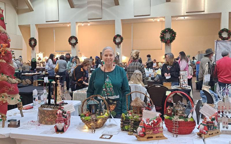 Megan Horn/The Clayton Tribune. Joy Lewis showcases her "Joyous Treasures" featuring jewelry, art, fairy gardens and more at the Festival of Trees last weekend.
