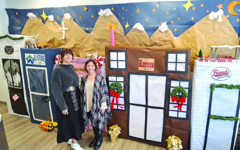 Megan Horn/The Clayton Tribune. Casidi Collins and Hayleigh Gosnell, tellers at My Georgia Credit Union in Clayton, are excited about their holiday decoration detailing popular Main Street businesses. The detailed display won them first place in the annual decorating contest held among the eight branch locations.