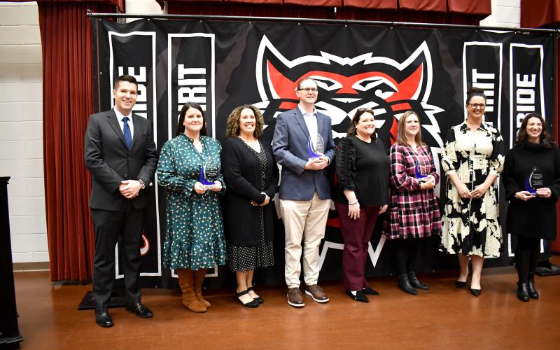 Megan Horn/The Clayton Tribune. The 2024-2025 Rabun County Schools Teachers of the Year (TOTY)were recognized during a special banquet and program on Nov. 21 in the Fine Arts Center (FAB) Band Room. Pictured are RCHS Principal Justin Spillers; RCHS TOTY Melissa Weeks; RCMS Principal Kechara Partin; RCMS and System TOTY Jason Crain; RCES Principal Keri Coleman; RCES TOTY Laurie Dills; RCPS Principal Carla Truelove; and RCPS TOTY Mary Dunham.