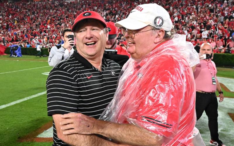 Georgia football head coach Kirby Smart (left) and father Sonny (right) share a heartfelt moment after a Bulldog victory. (Dean Legge/Dawg Post).