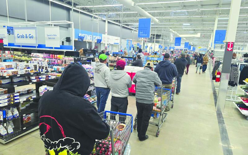 Enoch Autry/The Clayton Tribune. Walmart shoppers in Clayton pick up some last-minute items as the snow comes down outside on Jan. 10.