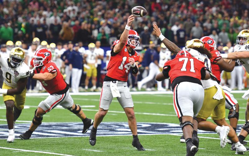 Wade Cheek/The Clayton Tribune. Gunner Stockton slings a pass amid heavy pressure from a Notre Dame defender, the Tiger product avoided multiple sacks in the loss while taking four and a fumble.