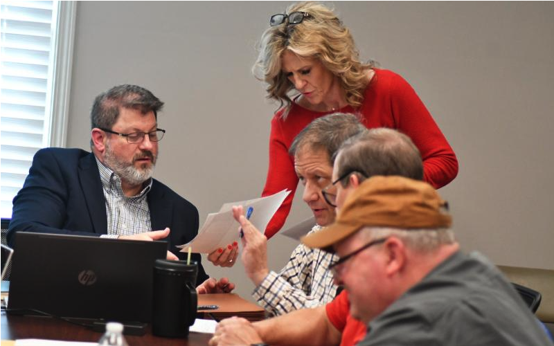 File Photo/Enoch Autry/The Clayton Tribune. RCWSA Finance Director Traci Adams hands paperwork to Jarrard &amp; Davis, LLC Attorney Jeffrey M. Strickland. The sale and closing on the water and sewer system between the City of Clayton and RCWSA was a significant event in 2024.