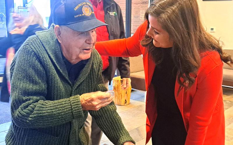 Megan Horn/The Clayton Tribune. Carolyn Culpepper with Family Hospice greets WWII U.S. Navy veteran Lt. J.G. Dr. Eldred Causey at the Vet-to-Vet Café for his 101st birthday on Feb. 11. Culpepper presented him with his button that has his motto, “Go with the Flow.”