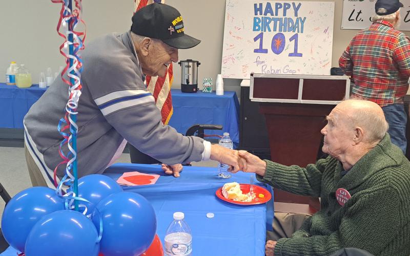 Megan Horn/The Clayton Tribune. 100-year-old WWII Army Veteran Andrew “Andy” Negra, left, shakes hands with 101-year-old WWII U.S. Navy Veteran Lt. J.G. Dr. Eldred Causey on his birthday Tuesday. The two got the opportunity to sit together and connect about their life experiences.