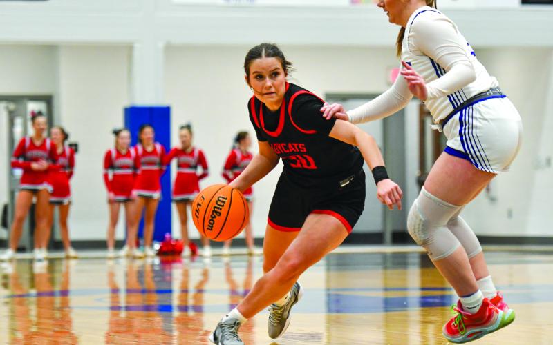 Wade Cheek/The Clayton Tribune. Rabun junior Madison Houck (30) attempts to pass by an Armuchee defender during Rabun’s win over Armuchee High School on Tuesday, Feb. 18. Houck scored nine points in the first-round playoff win.