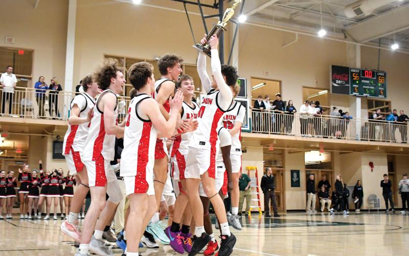 Wade Cheek/The Clayton Tribune. The Rabun County High School boys basketball team celebrates and hoists their region championship trophy after defeating Commerce High School 68-56 on Friday, Feb. 14. The second-seeded Wildcats were scheduled to host No. 31 Social Circle in the state tournament on Wednesday, Feb. 19.