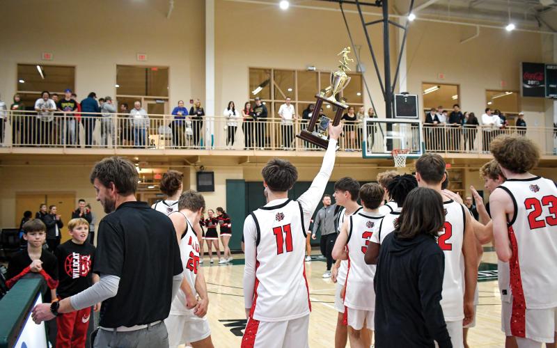 Wade Cheek/The Clayton Tribune. Senior basketball player Clayton Blalock (11) shows the crowd at Piedmont University his team’s newly earned region trophy after the Wildcats defeated Commerce High School 68-56 on Friday, Feb. 14. Rabun earned the No. 2 seed in this year’s 32-team playoff for Class A-DI.