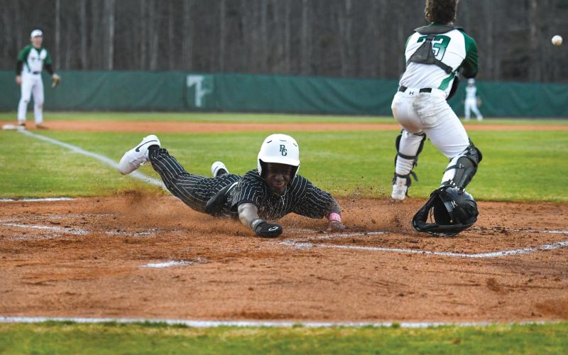 Wade Cheek/The Clayton Tribune. Senior infielder and Bryan College signee Denajh Williams dives in safely to score a run in Rabun Gap’s 19-0 win over Tallulah Falls School on Monday, Feb. 17.