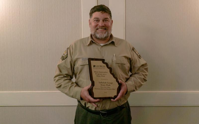 Submitted photo. Tallulah Gorge State Park won the Most Innovative Program on a State Park award. Pictured is West Malenke, Interpretive Ranger for Tallulah Gorge State Park, with the award.