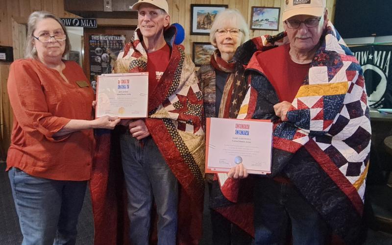 Megan Horn/The Clayton Tribune. United States Army Veterans and locals Gary Cantwell and Jon Jones are awarded Quilts of Valor by Karen Trombley, Georgia State Coordinator, and Sharon Ruth with Quilts of Valor during a special presentation at the VFW Post 4570 Friday, Feb. 28. Pictured are Trombley (left) Jones, Ruth and Cantwell.