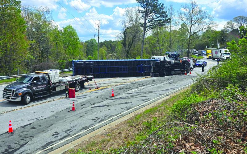 Enoch Autry/The Clayton Tribune. : A tractor trailer rests on its side on Highway 441 in Tallulah Falls on April 11 as crews attempt to clear the scene and get the vehicle upright.