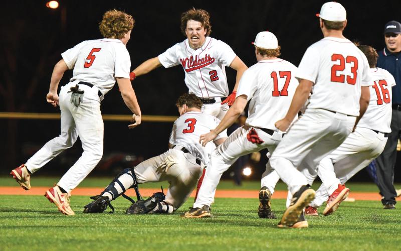Wade Cheek/The Clayton Tribune. Rabun County junior second baseman Ty Truelove gets mobbed by his teammates after smashing a walk-off double in the Wildcats’ 5-4 win over rival Elbert County on Friday, April 4. The Wildcats also captured at 4-3 over the visiting Blue Devils in the front end of the doubleheader.