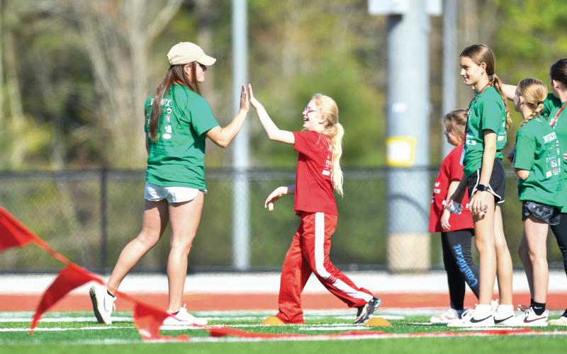 Wade Cheek/The Clayton Tribune. Deliah Justus celebrates a soccer goal with RCHS student Adelyn Thompson at this year’s Rabun County Special Olympics. Multiple athletic events were available for athletes at this year’s games.