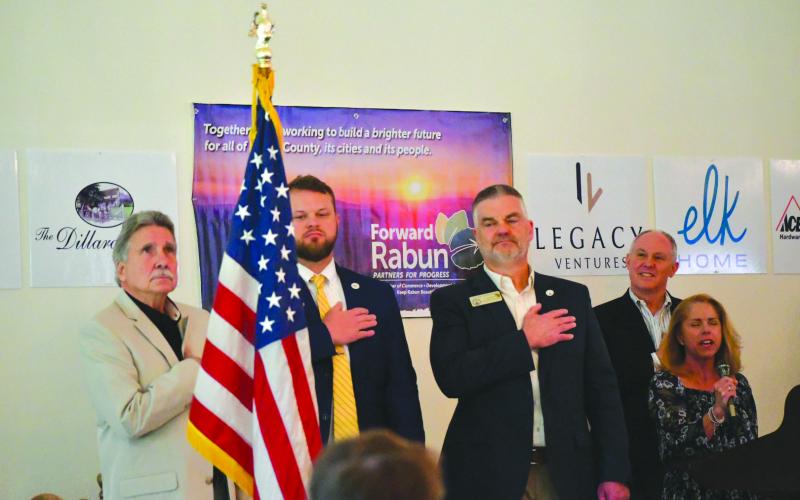 Enoch Autry/The Clayton Tribune. The Dillard House Conference Center served as the site for the Forward Rabun/Rabun County Chamber of Commerce Spring Business Breakfast as elected officials answered questions from the public. With Suzie Nixon Flaherty (far right) singing the “National Anthem,” Rabun County Commission Chair Greg James, State Sen. Bo Hatchett, State Rep. Victor Anderson and chamber president Rick Story stand at attention for the American Flag to begin the April 17 event.
