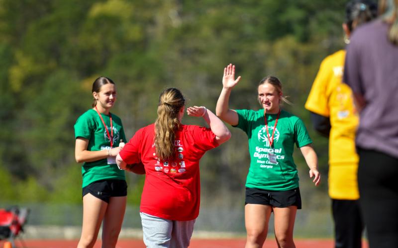 Wade Cheek/The Clayton Tribune. Katelin Free of Rabun County High School gives her buddy Millie Southards a high five during last week’s Rabun County Special Olympics at Frank Snyder Memorial Stadium.