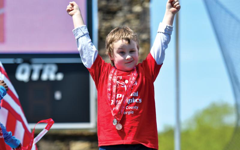 Wade Cheek/The Clayton Tribune. Rabun County Primary School student-athlete Devon Mauck celebrates his multiple medals at the Special Olympics.