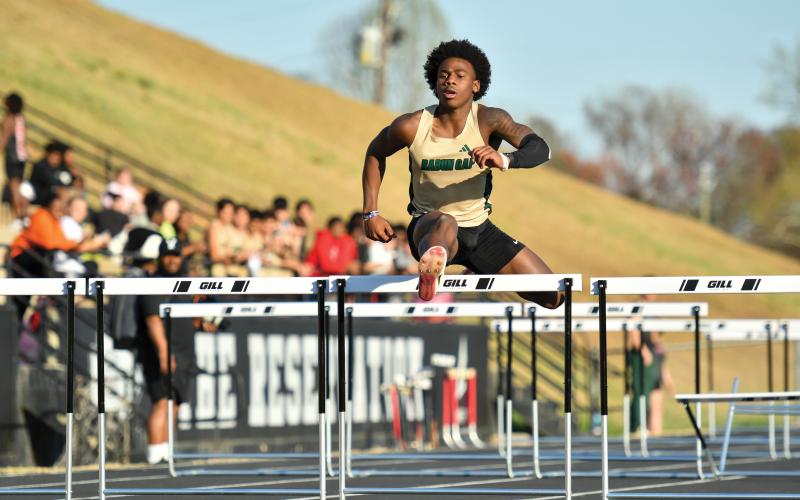 Wade Cheek/The Clayton Tribune. Junior Joshua Buckhalter leaps over a hurdle in the boys 110-meter hurdles during a meet at Stephens County High School on Thursday, March 27.