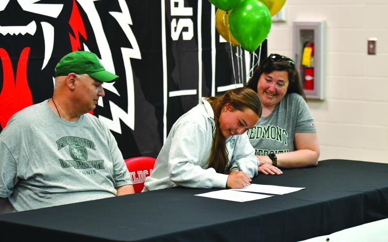 Wade Cheek/The Clayton Tribune. RCHS senior tennis player Lucy Harvey signed her national letter of intent to play tennis for Piedmont University on Friday, March 28. Harvey is currently the top singles player for the Lady Cats.