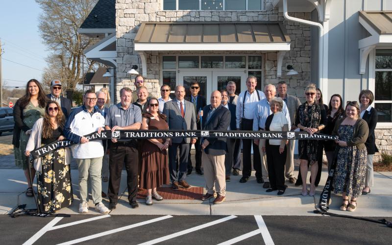 Zach Taylor/CNI News Service. Clarkesville Market Executive and Project Manager Sidney Roland cuts the ribbon with members of the Habersham Chamber of Commerce, Eclipse Brand Builders and Clarkesville officials backing him.