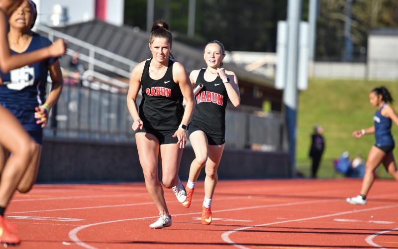 Wade Cheek/The Clayton Tribune. Isabella Buchanan hands off the baton to Madison Houck in a relay during Rabun County’s “Senior Night” meet against East Jackson.