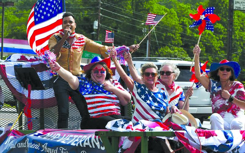Enoch Autry/The Clayton Tribune. A parade through Rabun County honored local veterans and celebrated America on Armed Forces Day on May 17 as a convoy rolled through Dillard, Mountain City, Tiger and Clayton. Here Ishmael Santos sings on a float with Konstantina Vinson, Barbara Rice, Sharon Purdy and Sue Studstil Crosley.