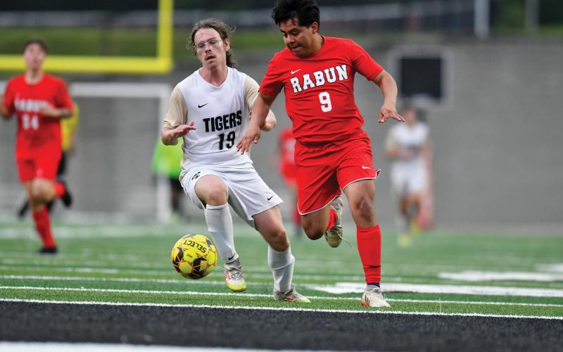 Wade Cheek/The Clayton Tribune. Enrique Tecu fights to keep possession in Rabun County’s 1-0 playoff win over Temple on Friday, May 2.