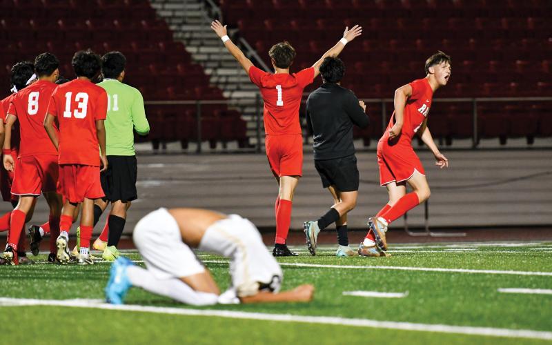 Wade Cheek/The Clayton Tribune. The Rabun County boys soccer team celebrates a second-round 1-0 playoff win over Temple as the Tigers mourn the end of their season. With the victory, the Wildcats advanced to the state quarterfinals.