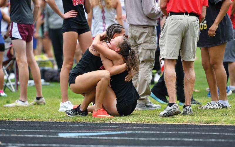 Wade Cheek/The Clayton Tribune. Arabella Nepa (left) hugs Lindsay Whitmire (right) after Whitmire finished her leg of the girls 4x800m relay at state sections in Bremen. The girls relay team squeaked into the state championship meet after Whitmire clinched the last spot with a lean into the finish line.