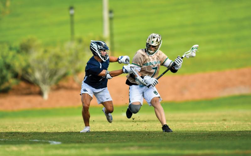 Wade Cheek/The Clayton Tribune. Sophomore lacrosse player Jack Shepard battles a Charlotte Latin defender during Rabun Gap’s 10-2 playoff win over the Hawks.