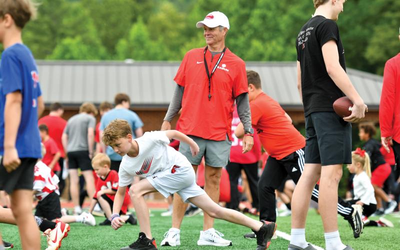 Wade Cheek/The Clayton Tribune. Rabun football head coach Rance Gillespie watches a slew of youth campers enjoy a fun-filled Saturday with the RCHS football team on Saturday, May 10.