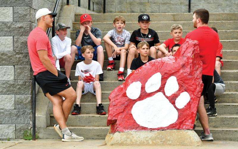 Wade Cheek/The Clayton Tribune. Rabun football legends Charlie Woerner (left) and Bailey Fisher (right) speak with campers about their football journeys while answering questions at Rabun’s Tri-State football kids camp on May 10.