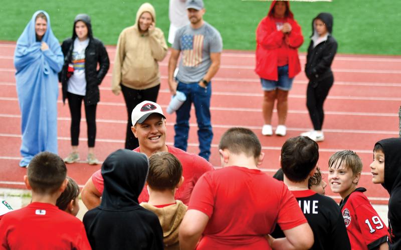 Wade Cheek/The Clayton Tribune. Former Rabun County standout and current Atlanta Falcon Charlie Woerner shares a laugh with the local youth at last weekend’s kids football camp.